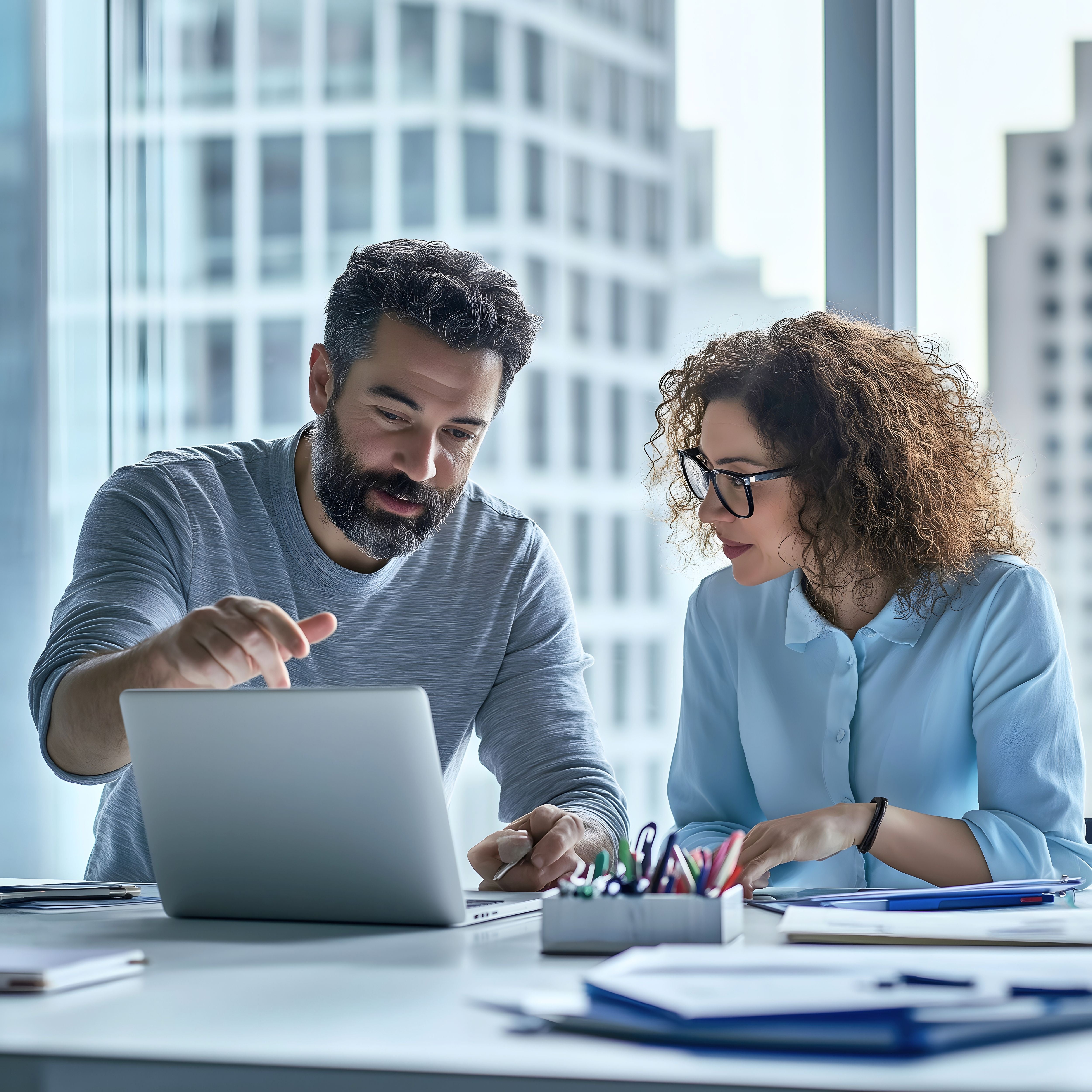 two employees discussing about work looking at the laptop